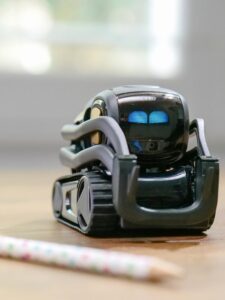 Explore the futuristic design of a miniature AI-powered robotic toy with modern technology elements.